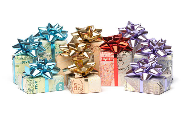 Gift of money "Sterling banknotes wrapped as a gift, isolated on white." twenty pound note stock pictures, royalty-free photos & images