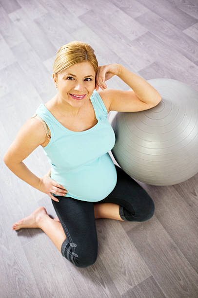 donna incinta di relax sul pallone per fitness. - human pregnancy prenatal care relaxation exercise ball foto e immagini stock