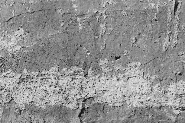 istock White concrete wall with deep scratches and chips. Various variations of abrasions. 1868475976