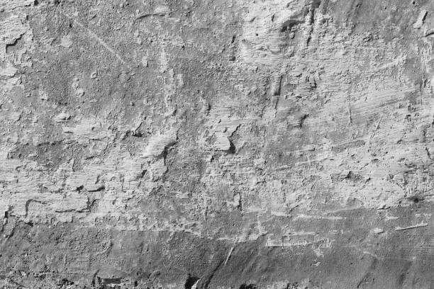 istock White concrete wall with deep scratches and chips. Various variations of abrasions. 1868475977