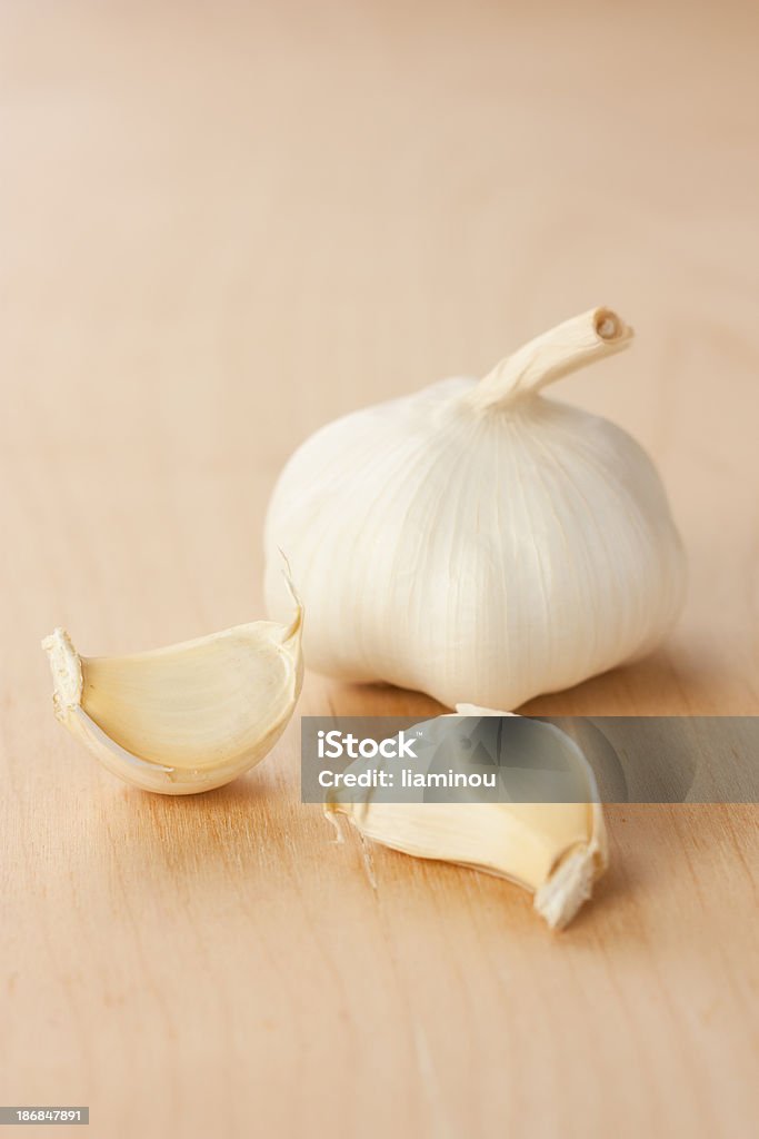 garlic head with two gloves garlic head with two gloves on wooden table Color Image Stock Photo