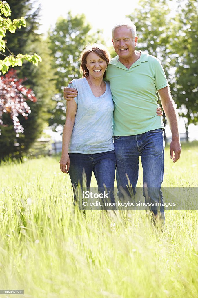 Retrato de pareja Senior caminando en paisaje de verano - Foto de stock de 50-59 años libre de derechos