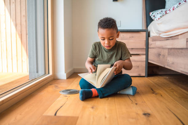 istock Mixed Race Boy Reading A Book In A Domestic Bed Room 1868481512