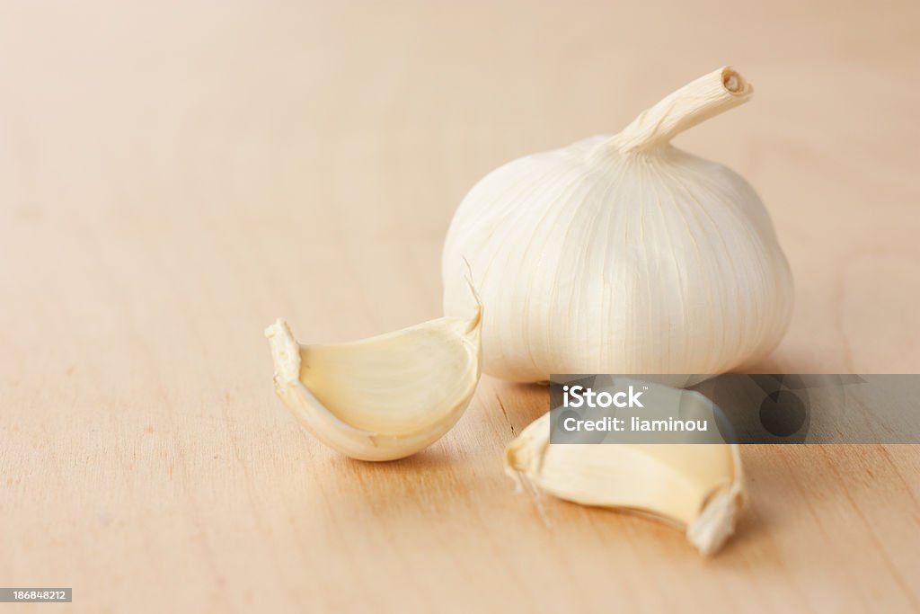 garlic head with two cloves garlic head with two cloves on wooden table Color Image Stock Photo