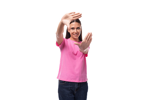 young stylish brunette lady dressed in a pink t-shirt feels optimistic.