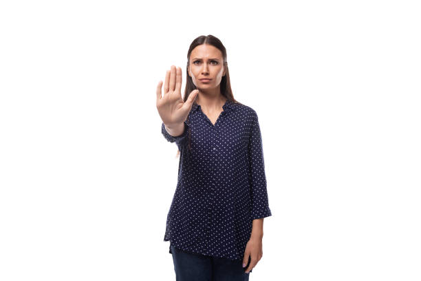 istock young brunette advertiser woman dressed in a blue blouse with a polka dot pattern shows stop 1868483770