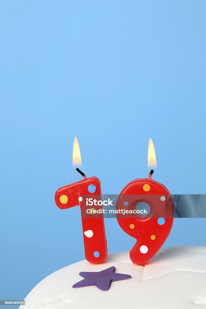 19th Birthday candles Red Birthday candles against blue background Number 19 Stock Photo