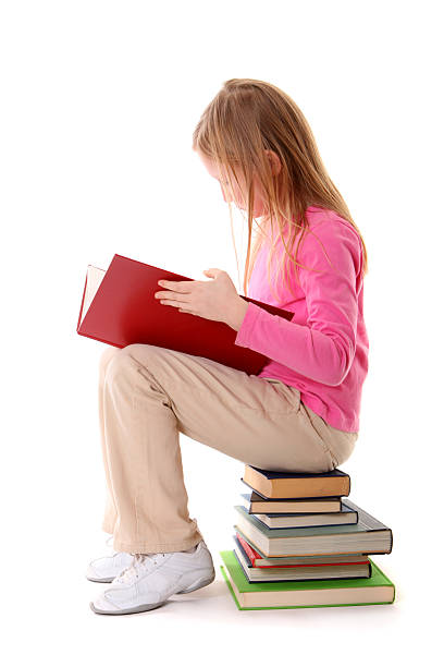 istock girl sitting on books reading 186850424