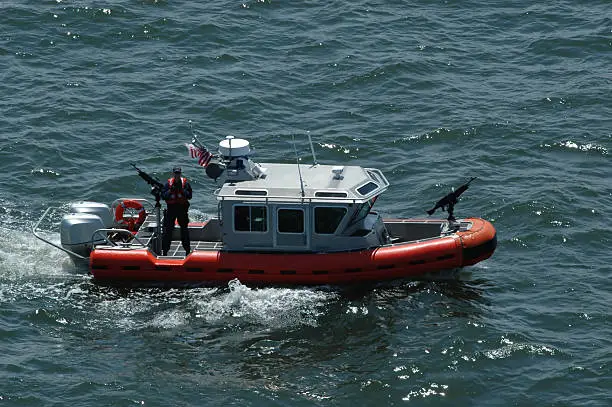 A Coast Guard gunman (face is obscured) stands beside his high power machine gun.  Aerial View.More marine and Chesapeake Bay images: