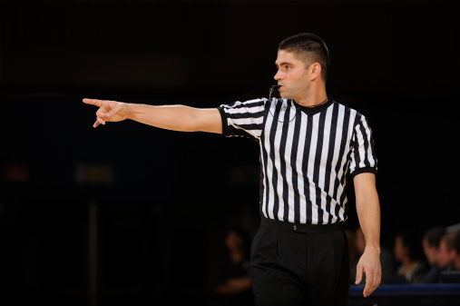 A basketball referee makes call during a game.