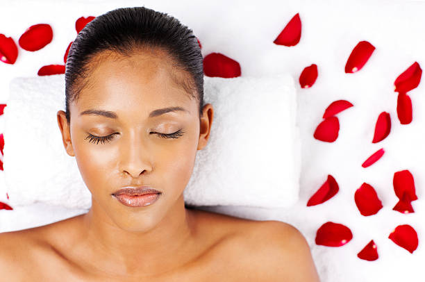 istock Young Woman Lying on a Bed with Rose Petals 186852012