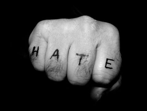 A fist with the word HATE written on the fingers.