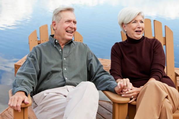 istock Happy senior couple sitting by water 186852873