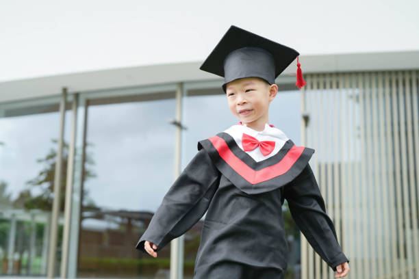 istock Asian elementary age boy wearing graduation caps and gowns 1868529778
