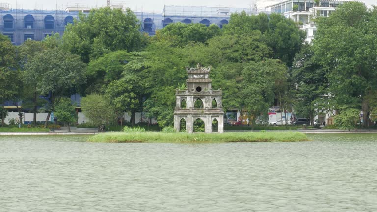 Lake water flowing past small architectural design. Tourist attractions Hanoi