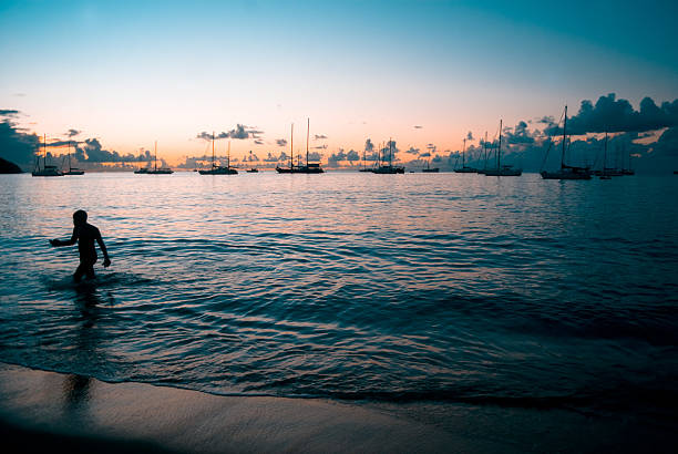 istock surreal beach with silhouetted boy and yachts 186854741