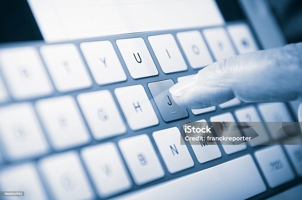 Mano tocando la pantalla de una tableta digital - Foto de stock de Azul libre de derechos