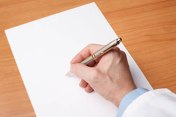 medico mano scrivere sul foglio di carta bianco - medical exam foto e immagini stock