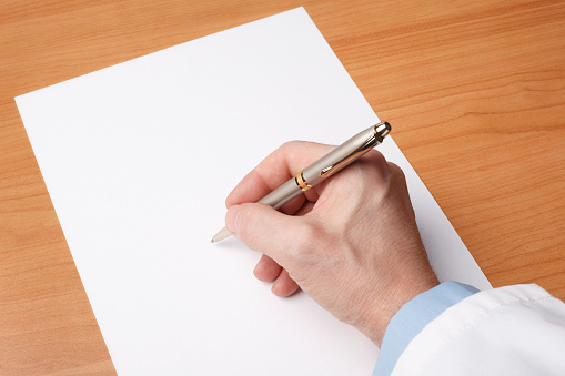 Doctor’s hand writing on blank sheet of paper.