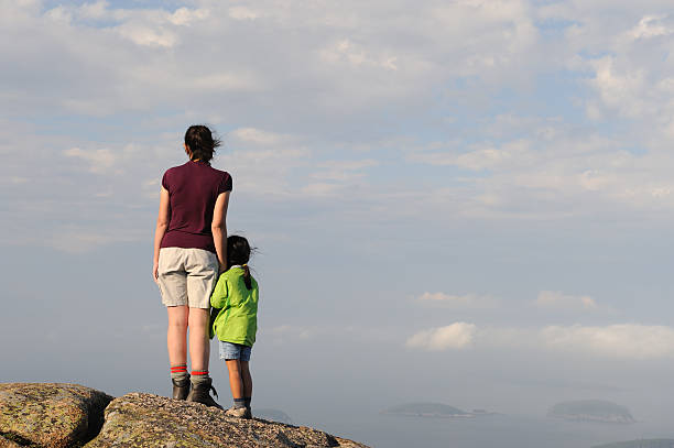 istock Mother and Daughter on Mountain Summit Overlooking Ocean 186855473