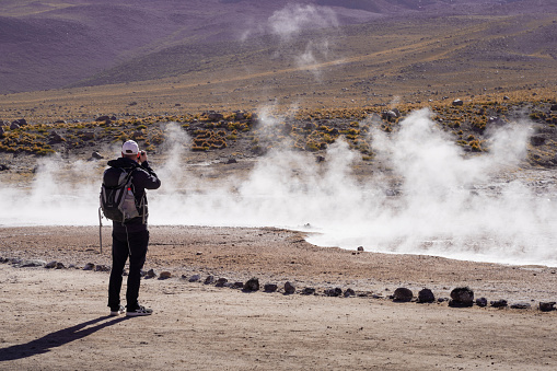 San Pedro de Atacama, Chile - October 26.Photographer at Tatdio Geyser. Atacama Desert. Chile.