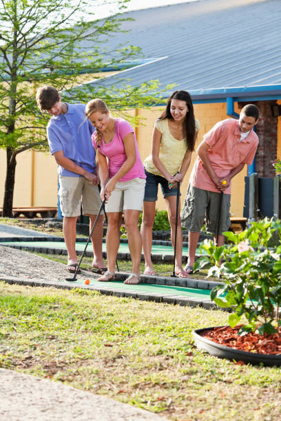 istock Teenage couples playing miniature golf 186855924