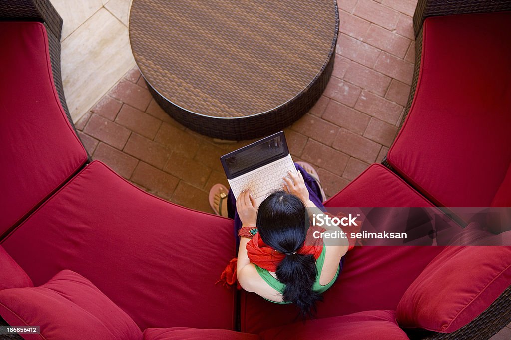 Canapé rouge autour de table jeune femme avec un ordinateur portable - Photo de Activités de week-end libre de droits