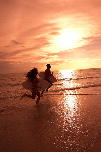 istock Two surfers silhouetted by a beautiful sky 186856935