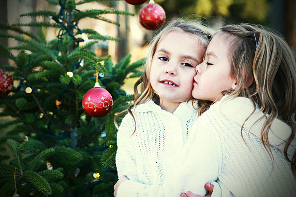 A stock photo of Identical twin brothers having fun by the Christmas Tree. High ISO shot - photographed using the Canon EOS 1DX Mark II