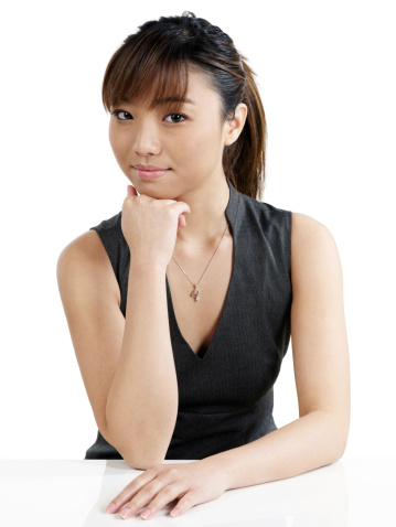 Business woman sitting with hand on chin.