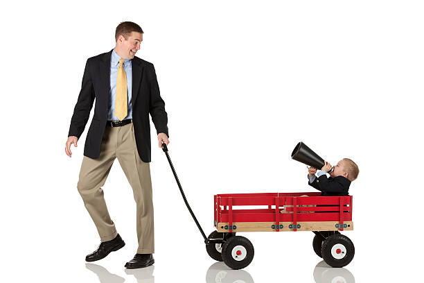 istock Father pulling his son in cart blowing a bullhorn 186857649