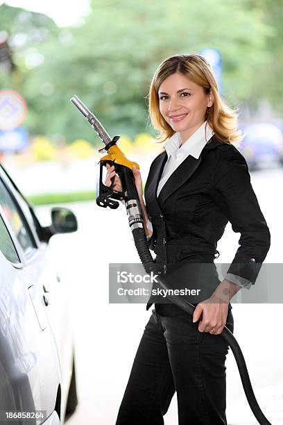 Mujer Echando Gasolina En Gas Station Foto de stock y más banco de imágenes de Adulto - Adulto, Adulto joven, Agarrar