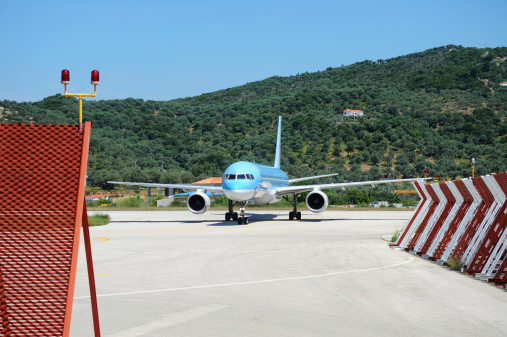 A passenger aircraft landing and manoeuvring at an exotic airport.