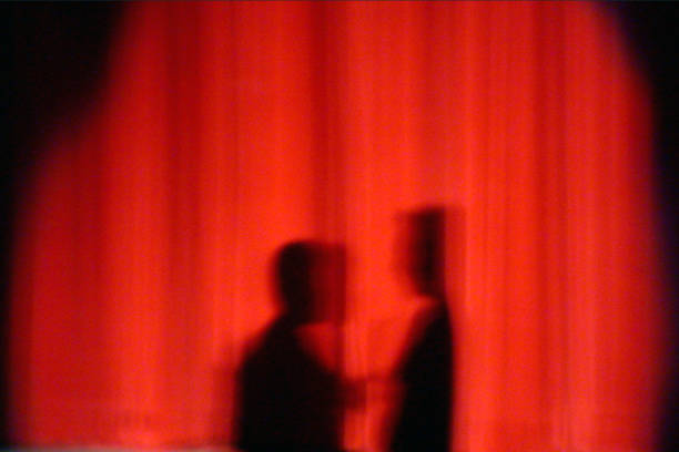 silhouette 2 people shadows on red curtain stock photo