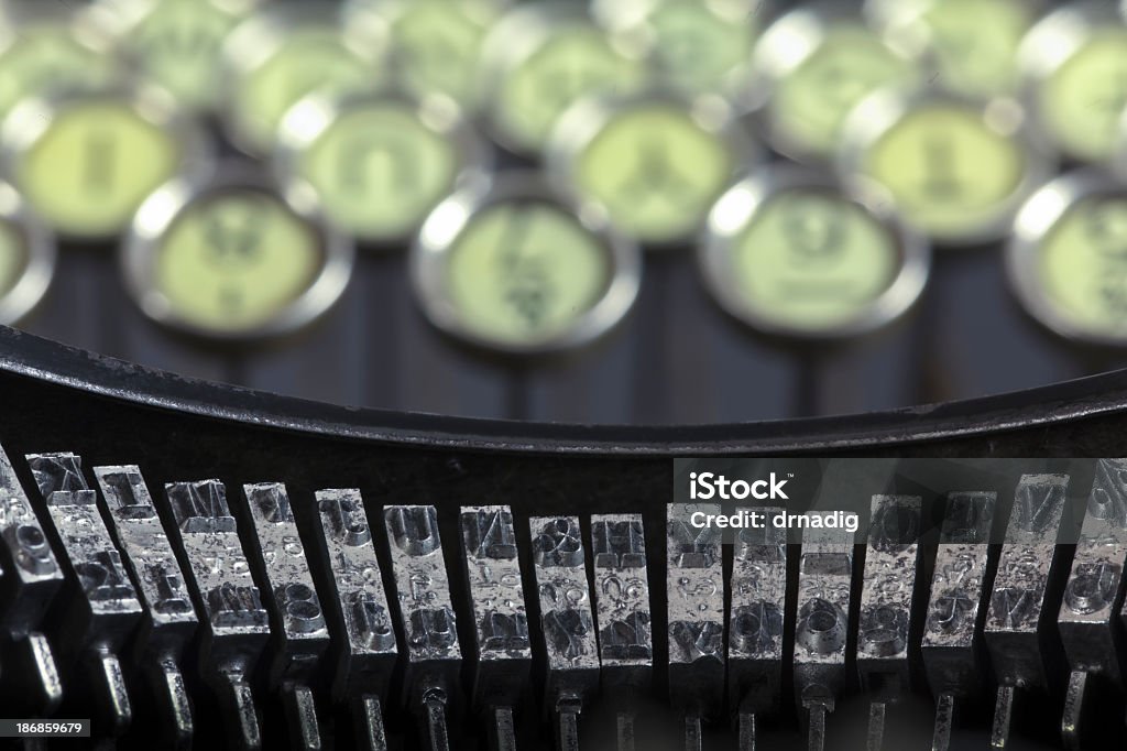 Antique Typewriter Keyboard and Hammers An antique black manual typewriter keyboard with its round keys and narrow oblong type hammers was common in offices before the invention of the electric typewriter. Alphabet Stock Photo