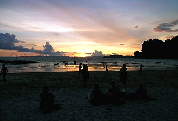 istock people relaxing at sunset on a beach 186859846