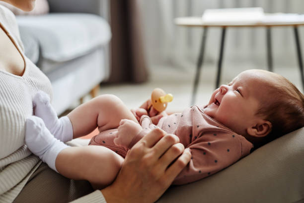 istock Mother Holding Smiling Infant on Lap 1868599146