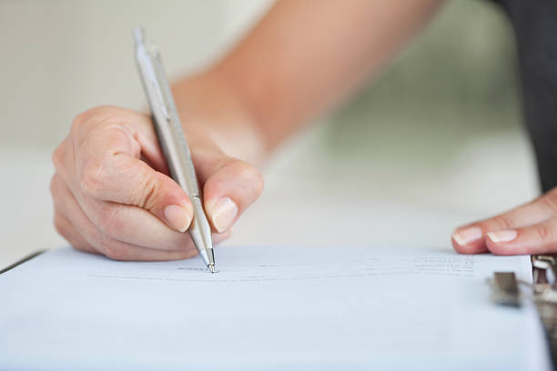 istock Businesswoman Holding Pen and Writing 186860190