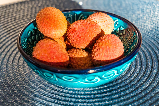 Lychee fruit on blue plate background, fresh ripe lychee peeled from lychee tree at tropical fruit Thailand in summer. The concept of healthy dietary and vegan food. High quality photo