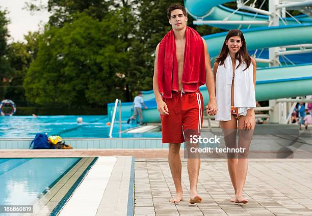 Joven Pareja Caminando De La Piscina Foto de stock y más banco de imágenes de Mujeres - Mujeres, Mujeres jóvenes, Piscina