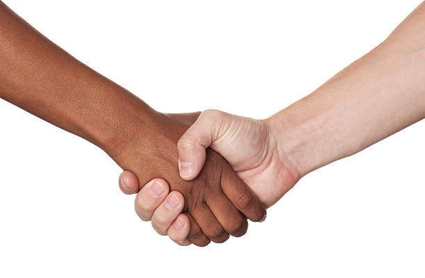 Black and white hands clasped against a background of office blinds.