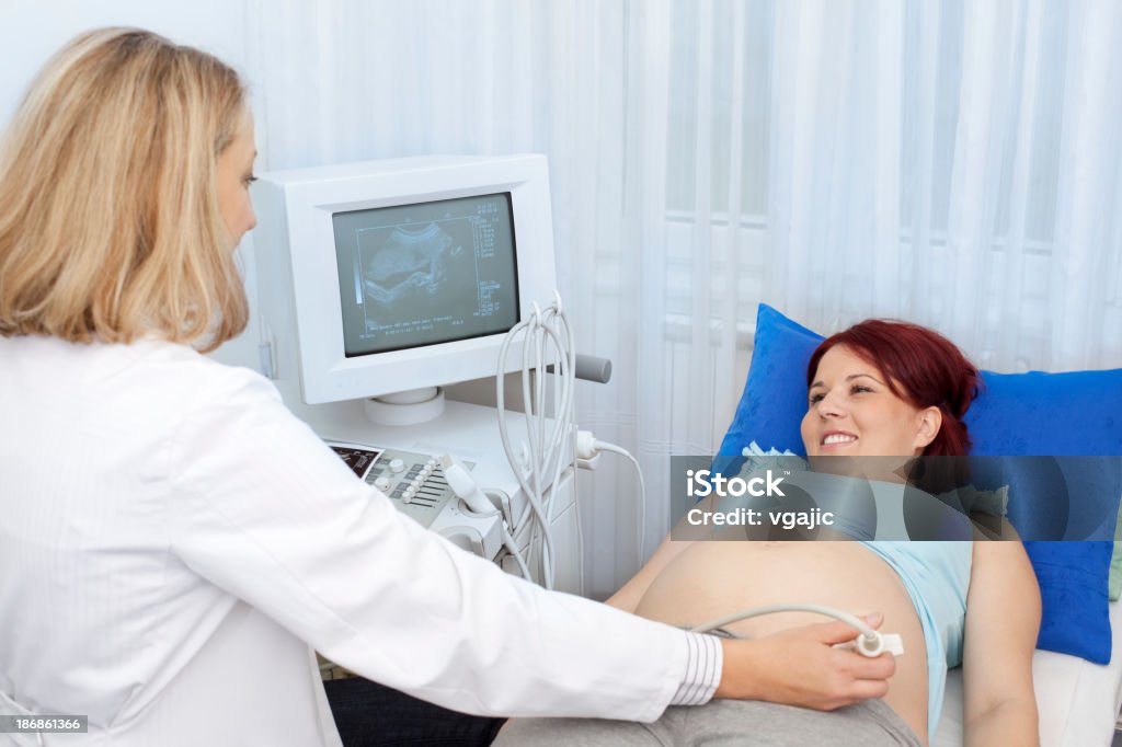 Mujer embarazada teniendo una ecografía - Foto de stock de 30-34 años libre de derechos