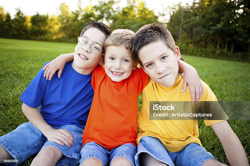 Felice giovane ragazzo seduto insieme all'esterno - Foto stock royalty-free di 10-11 anni