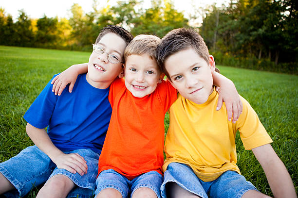 istock Happy Young Boys Sitting Together Outside 186861550