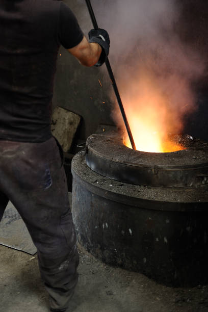 istock Foundry worker stirring the molten metal 186862757