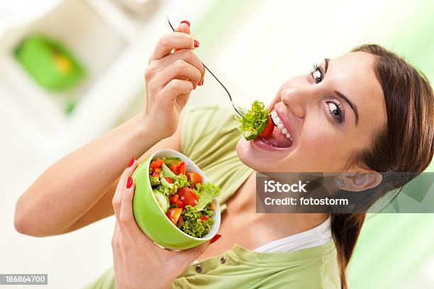 Chica Comiendo Ensalada Saludable Foto de stock y más banco de imágenes de Ensalada - Ensalada, Morder, Lechuga