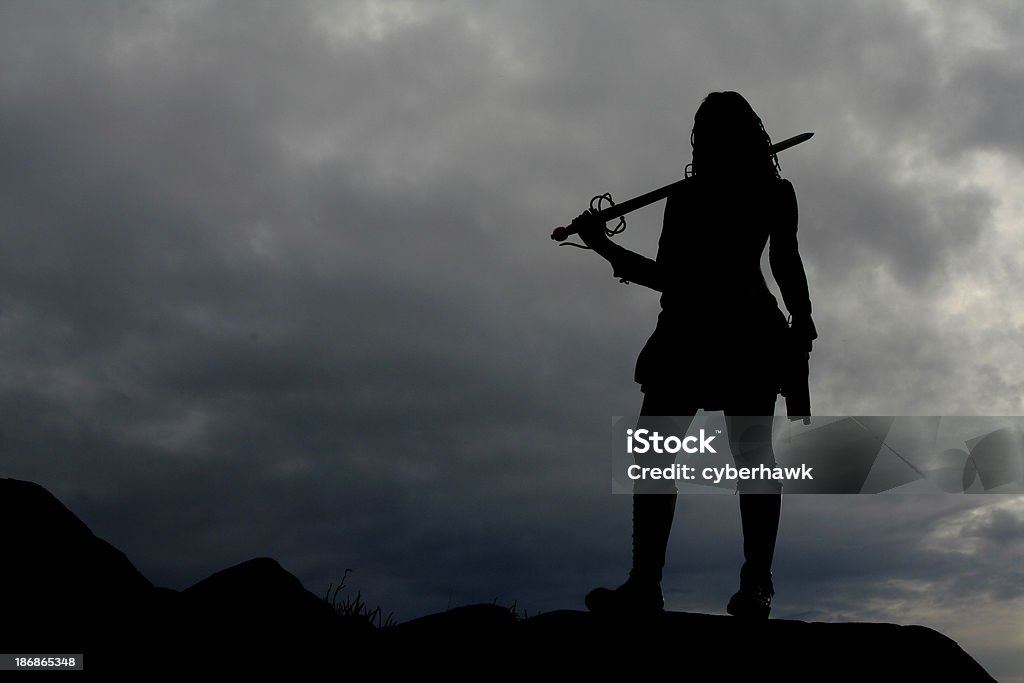 Warrior Woman Silhouette The silhouette of a warrior woman with storm clouds in the background. Pirate - Criminal Stock Photo