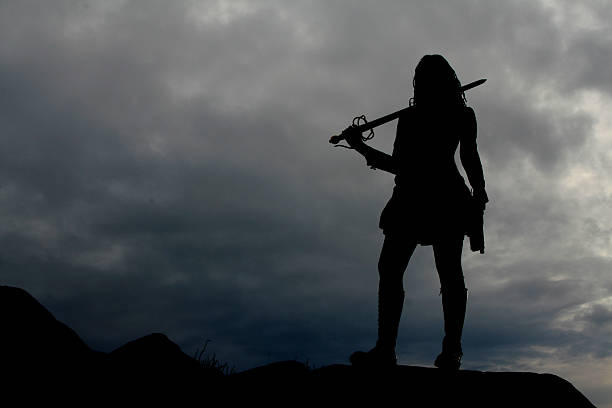 Warrior Woman Silhouette The silhouette of a warrior woman with storm clouds in the background. warrior person stock pictures, royalty-free photos & images
