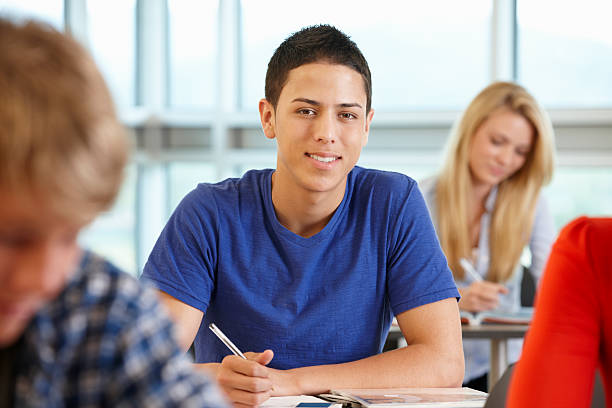 istock Hispanic teenage boy in class smiling to camera 186865730