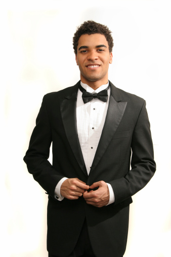 Young minority guy in a tuxedo isolated on white